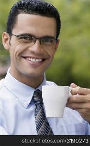 Portrait of a businessman holding a cup of coffee and smiling