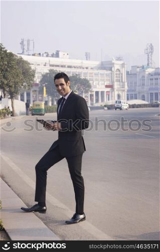 Portrait of a businessman holding a digital tablet , INDIA , DELHI