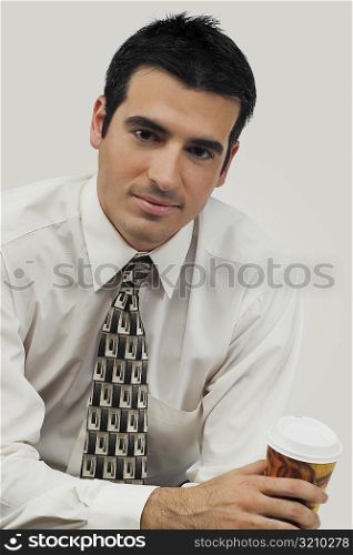 Portrait of a businessman holding a disposable cup