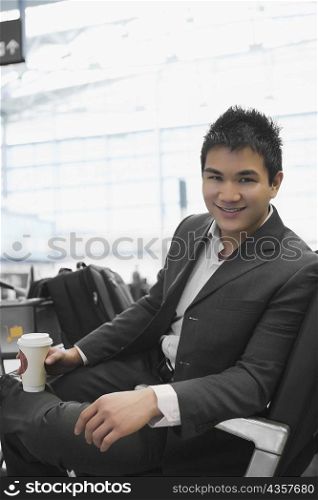 Portrait of a businessman holding a disposable glass