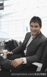 Portrait of a businessman holding a disposable glass