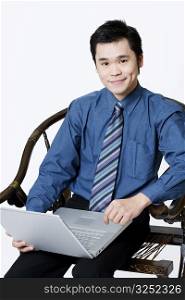 Portrait of a businessman holding a laptop and smirking
