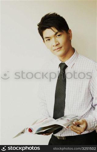 Portrait of a businessman holding a magazine