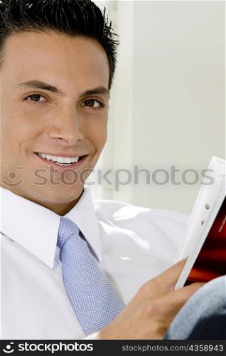 Portrait of a businessman holding a magazine