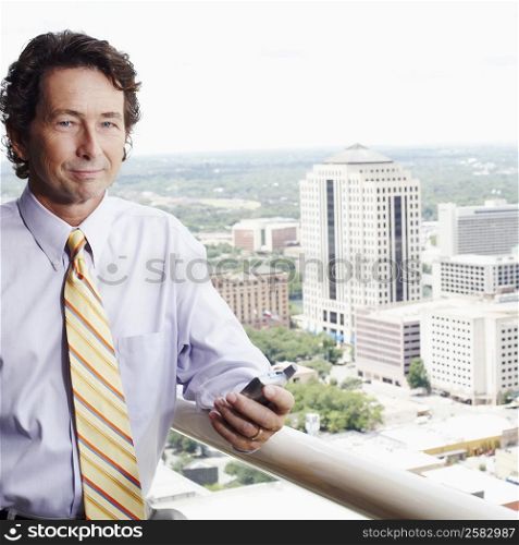 Portrait of a businessman holding a mobile phone