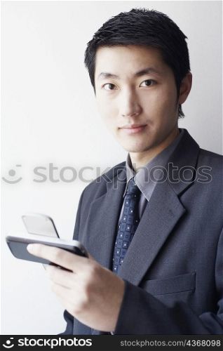 Portrait of a businessman holding a mobile phone