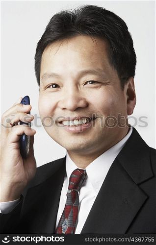 Portrait of a businessman holding a mobile phone smiling