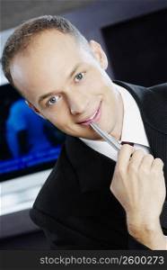Portrait of a businessman holding a pen and smiling