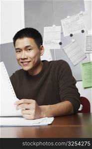 Portrait of a businessman holding a printout smiling
