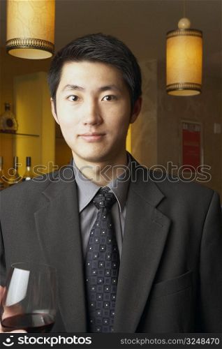 Portrait of a businessman holding a red wineglass