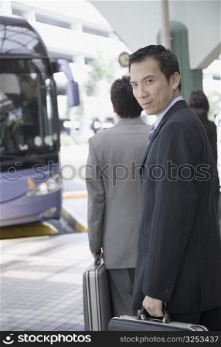 Portrait of a businessman holding a suitcase and walking