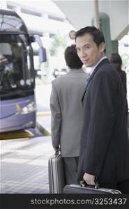 Portrait of a businessman holding a suitcase and walking