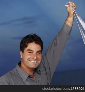 Portrait of a businessman holding a tie in his raised hand