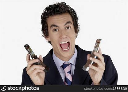 Portrait of a businessman holding mobile phones