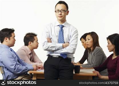 Portrait of a businessman in a meeting with business executives behind him