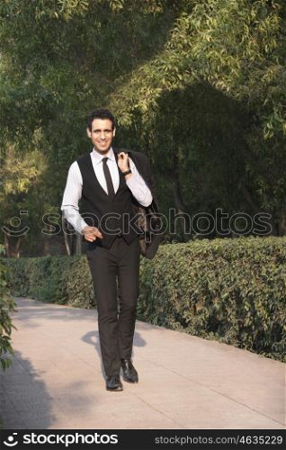 Portrait of a businessman in park smiling , INDIA , DELHI