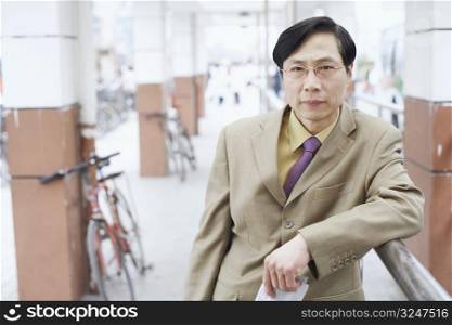 Portrait of a businessman leaning against a railing