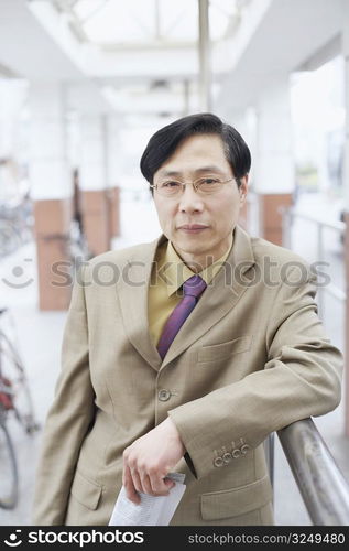 Portrait of a businessman leaning against a railing