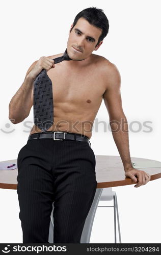 Portrait of a businessman leaning against a table