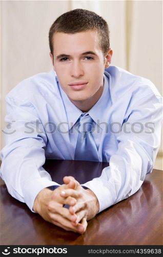 Portrait of a businessman leaning on a table
