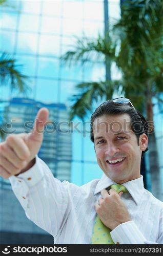 Portrait of a businessman making a thumbs up sign and smiling