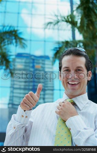 Portrait of a businessman making a thumbs up sign and smiling