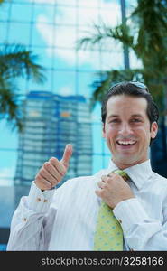 Portrait of a businessman making a thumbs up sign and smiling