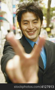 Portrait of a businessman making the peace sign