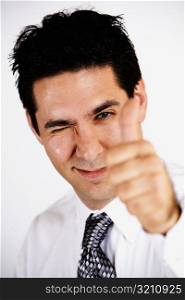 Portrait of a businessman making Thumbs Up sign and winking