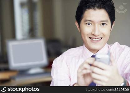 Portrait of a businessman operating a personal data assistant with a digitized pen and smiling