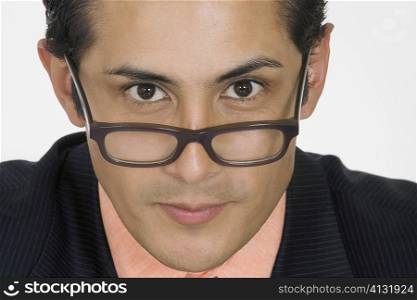Portrait of a businessman peeking over his eyeglasses