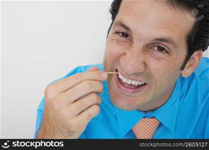 Portrait of a businessman picking his teeth in an office