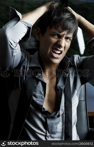 Portrait of a businessman pulling his hair in anger