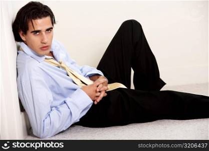 Portrait of a businessman reclining against a wall