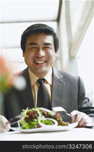 Portrait of a businessman seated at the table in a restaurant smiling