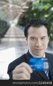 Portrait of a businessman showing a credit card