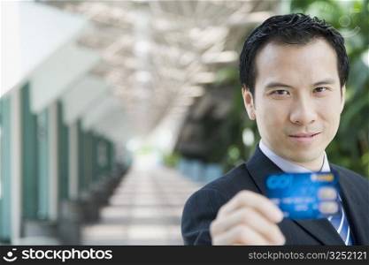 Portrait of a businessman showing a credit card