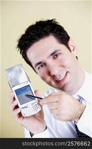 Portrait of a businessman showing a mobile phone