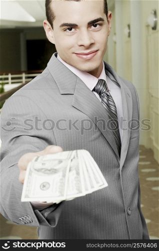 Portrait of a businessman showing American paper currency