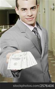 Portrait of a businessman showing American paper currency