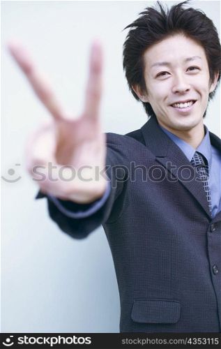 Portrait of a businessman showing the peace sign
