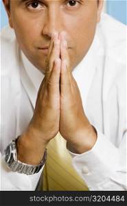 Portrait of a businessman sitting in a prayer position