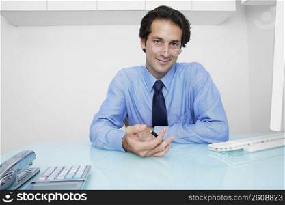 Portrait of a businessman sitting in an office and holding a pen
