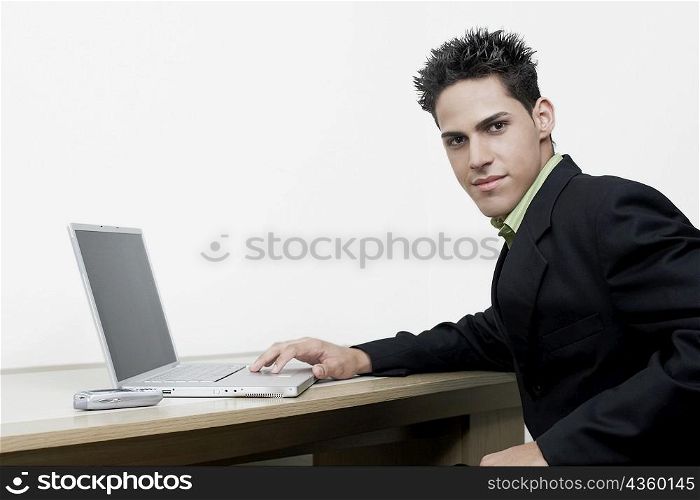 Portrait of a businessman sitting in front of a laptop