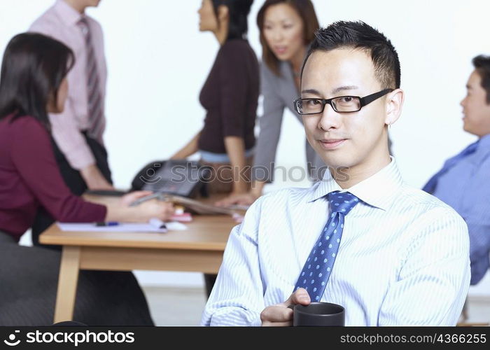 Portrait of a businessman sitting on a chair holding a coffee cup