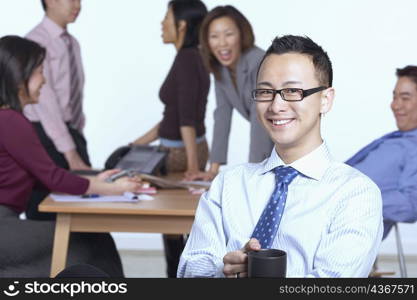 Portrait of a businessman sitting on a chair holding a coffee cup