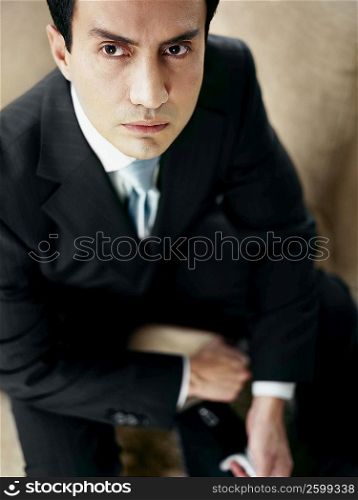 Portrait of a businessman sitting on a couch and holding a bag