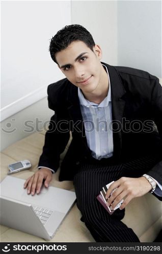 Portrait of a businessman sitting on a couch with a laptop