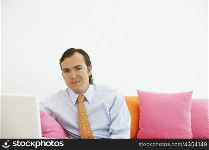 Portrait of a businessman sitting on a couch with a laptop
