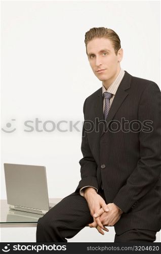 Portrait of a businessman sitting on a desk